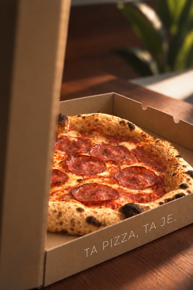 A pizza in a box printed with Ta pizza, ta je.